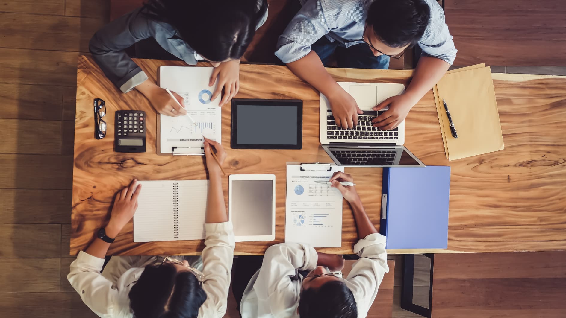 photo de haut d'une équipe travaillant sur un bureau avec ordinateur